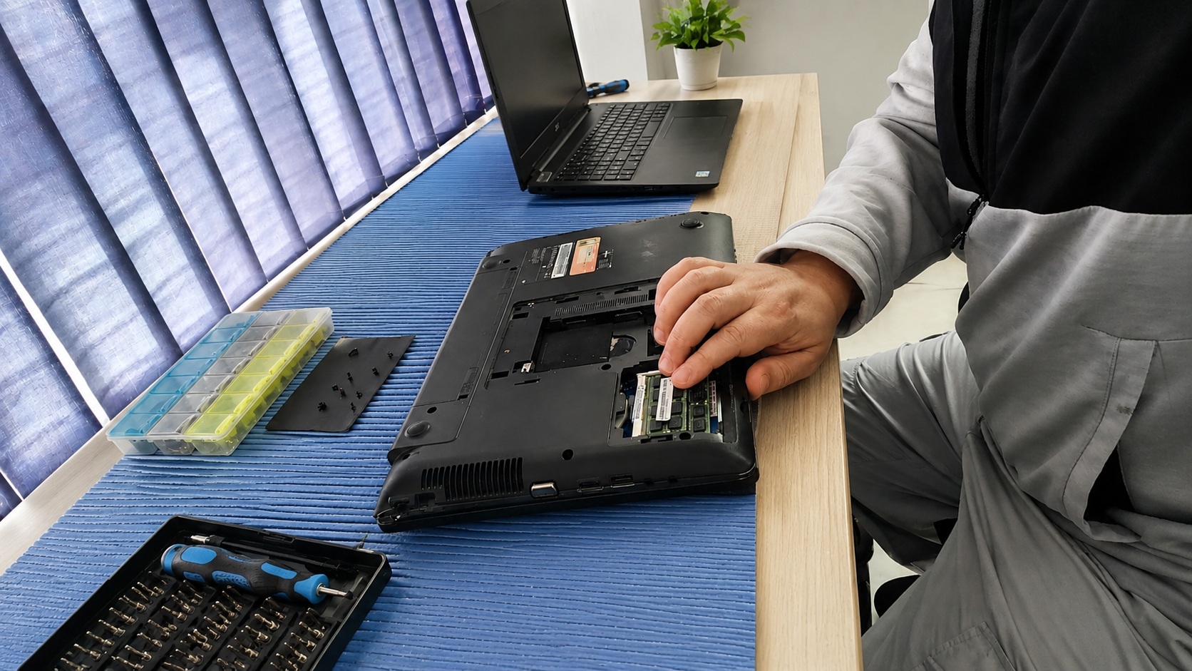 Technician repairing a laptop at the Oriya Computers workshop in Berea